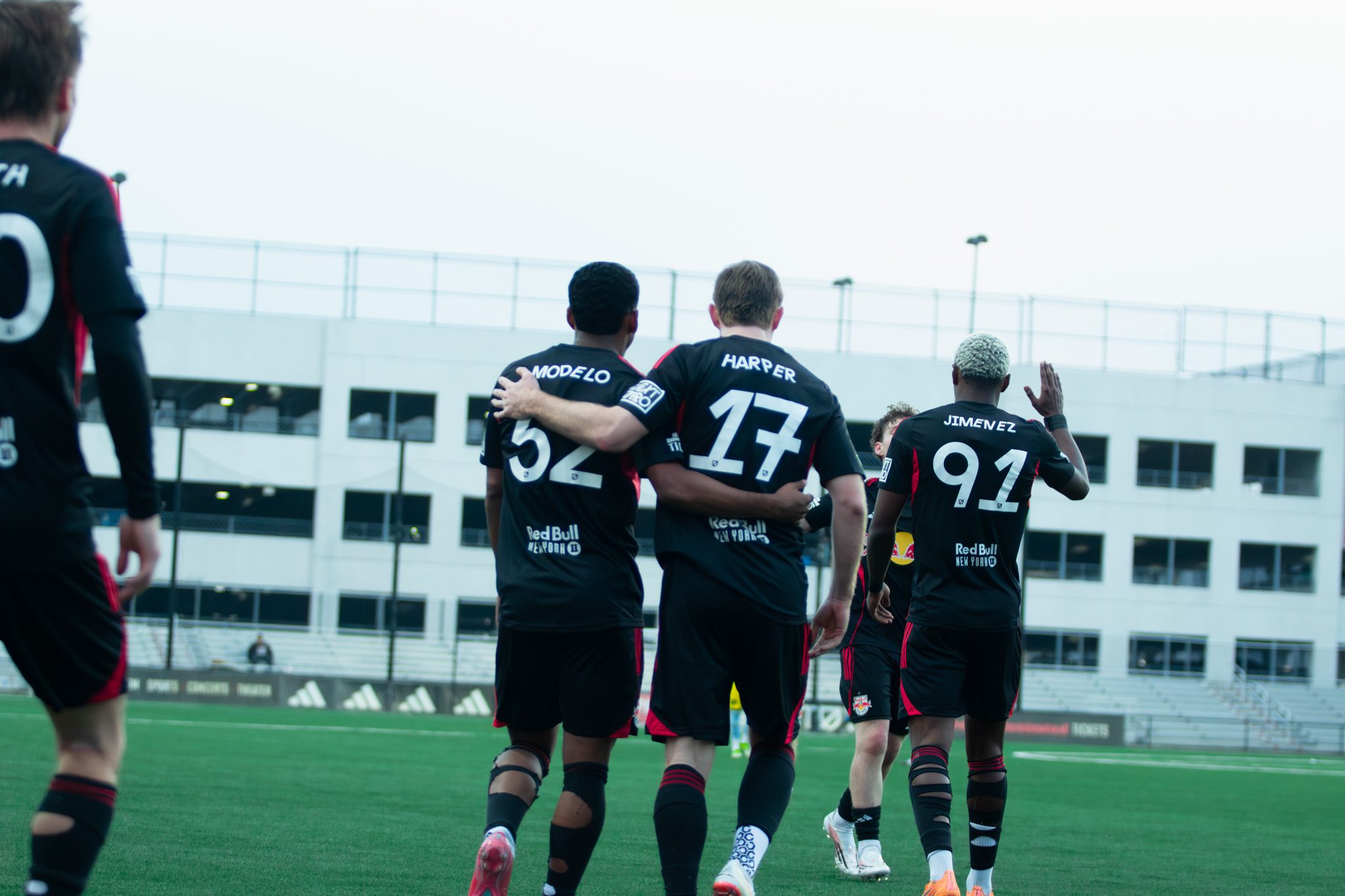 Cameron Harper is embraced by Red Bull II teammates.