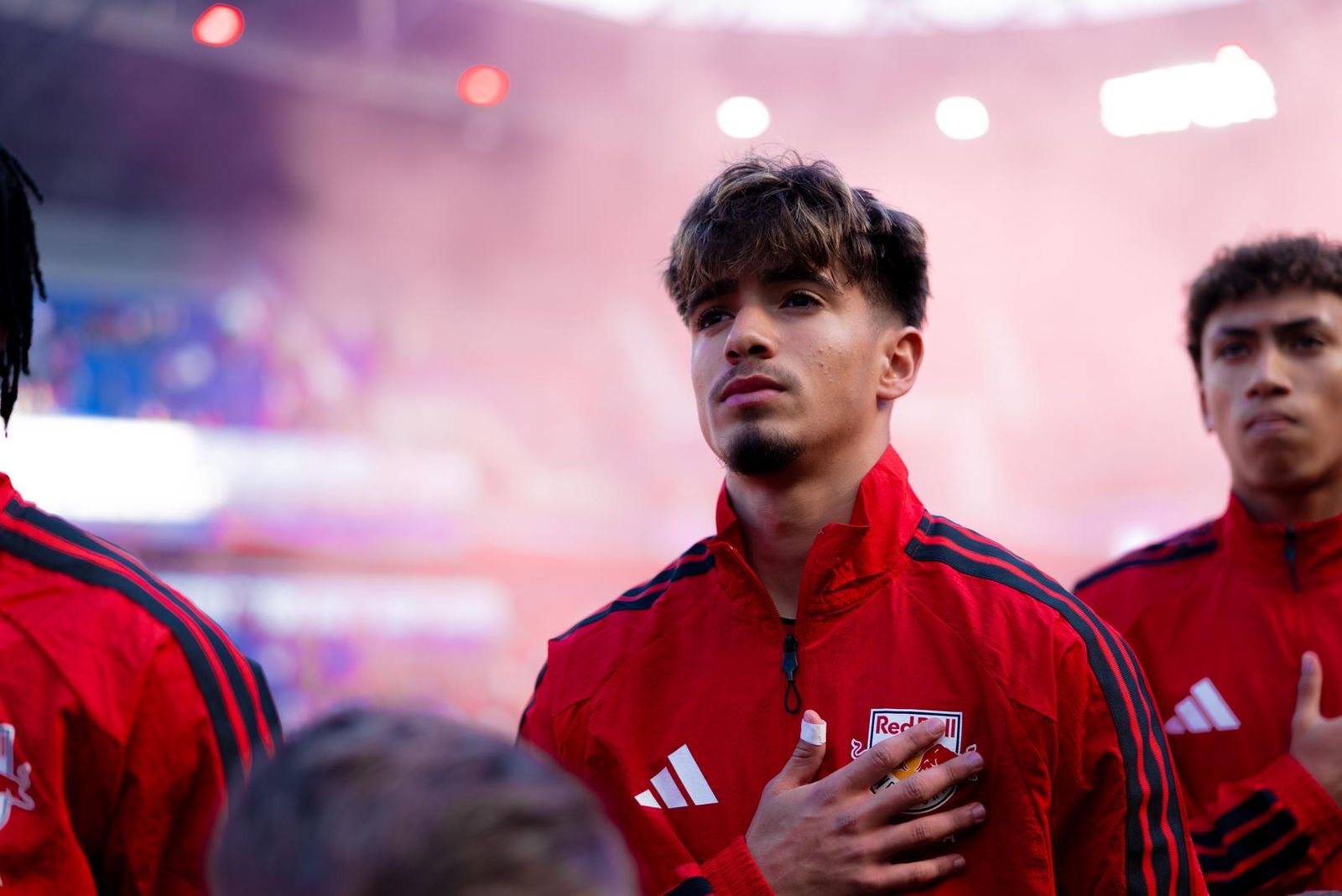 Red Bull New York defender Matthew Dos Santos (center) stands during the national anthem.