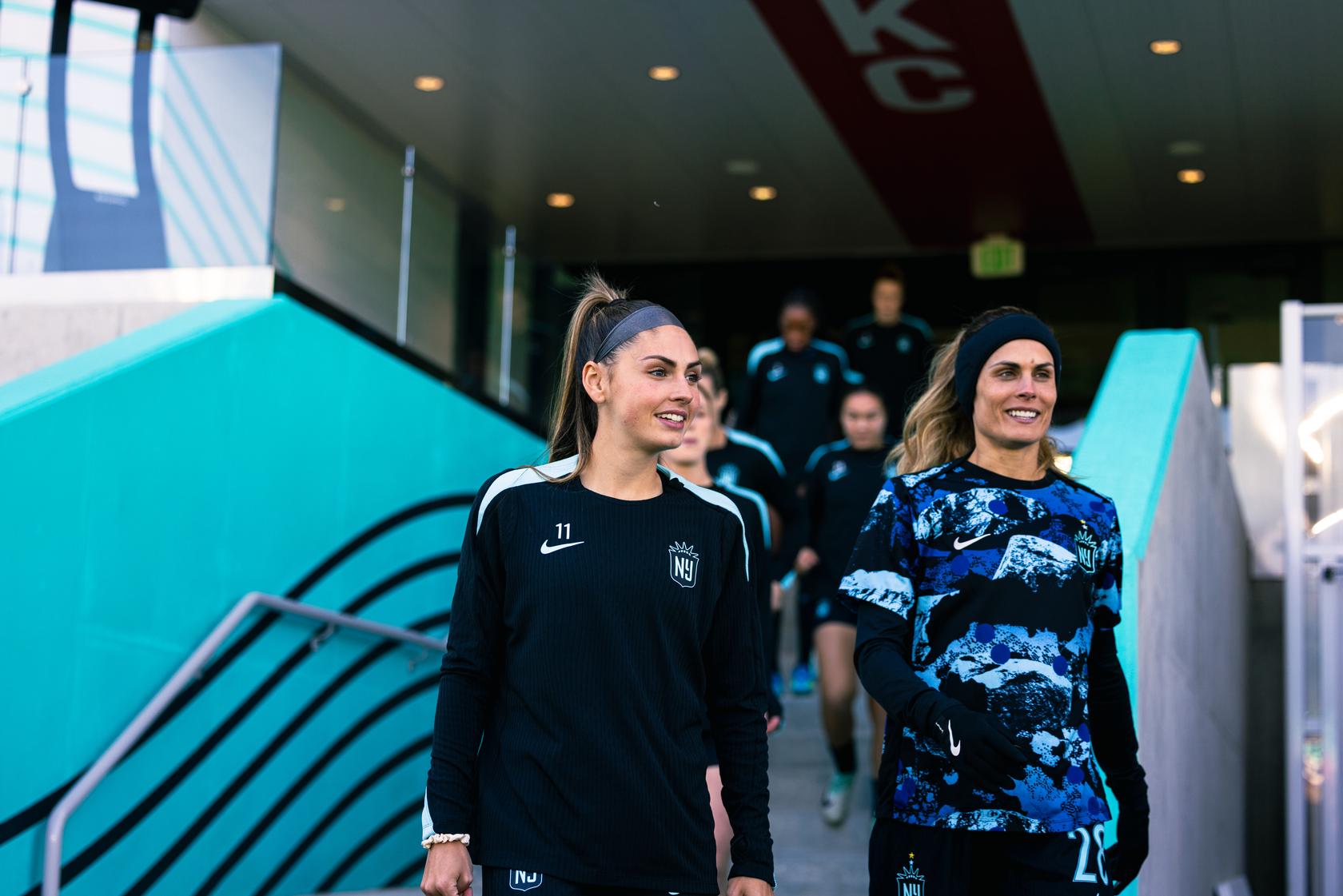 Gotham FC teammates Sarah Schupansky and Katie Lampson walk along the pitch.