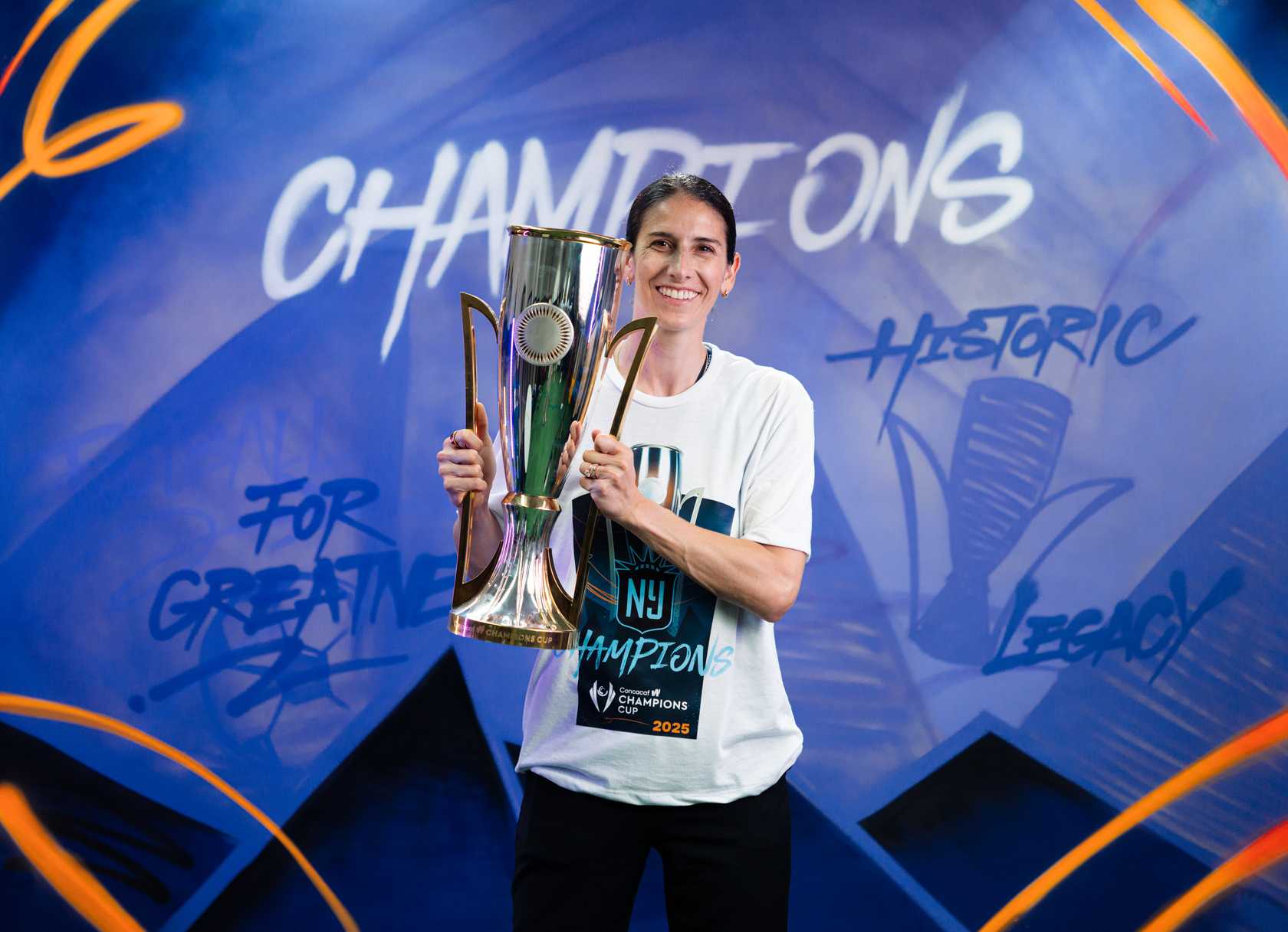Gotham FC general manager Yael Averbuch West holds the Concacaf W Champions Cup trophy.