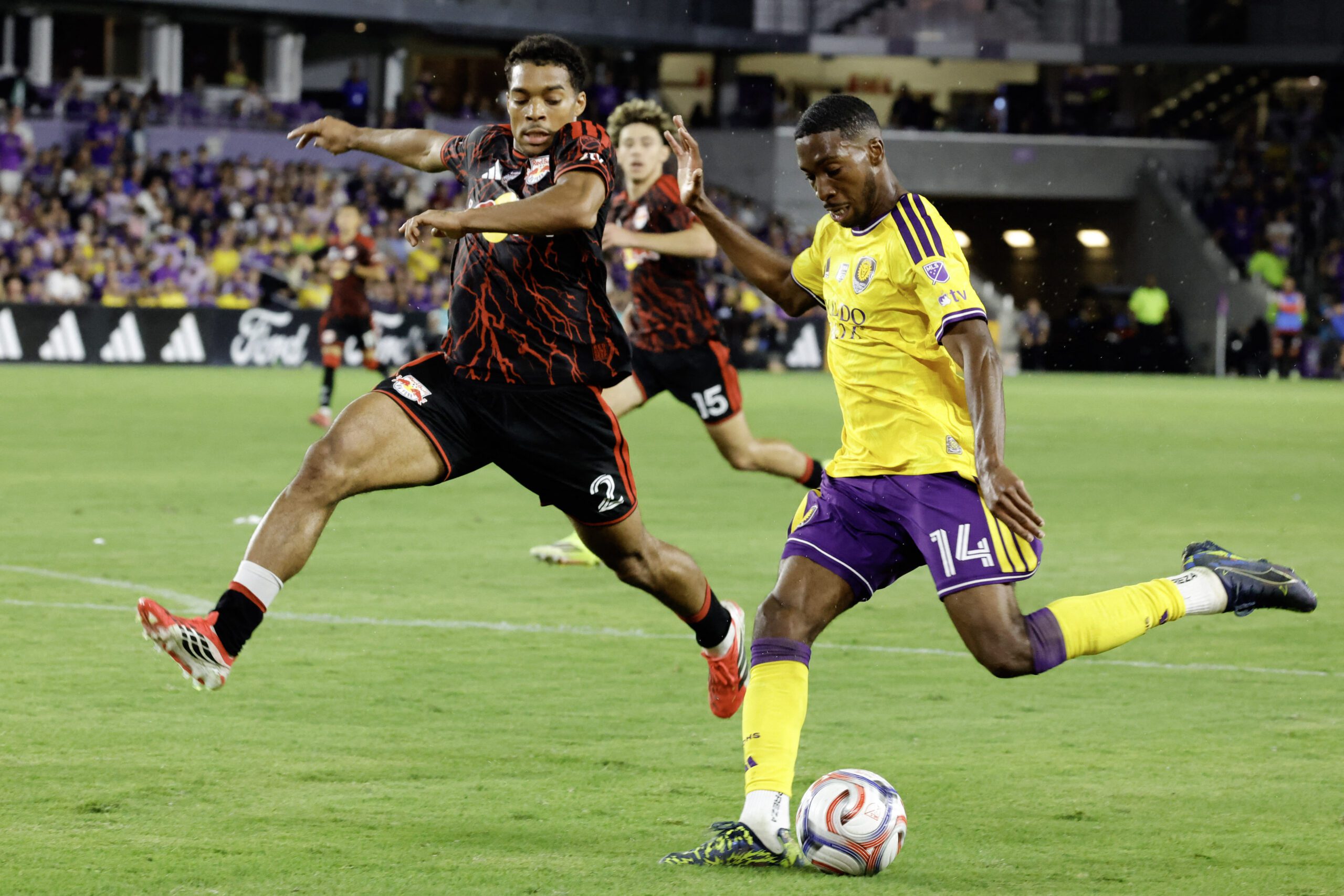 Red Bull New York defender Justin Che  challenges Orlando City SC forward Tyrese Spicer.