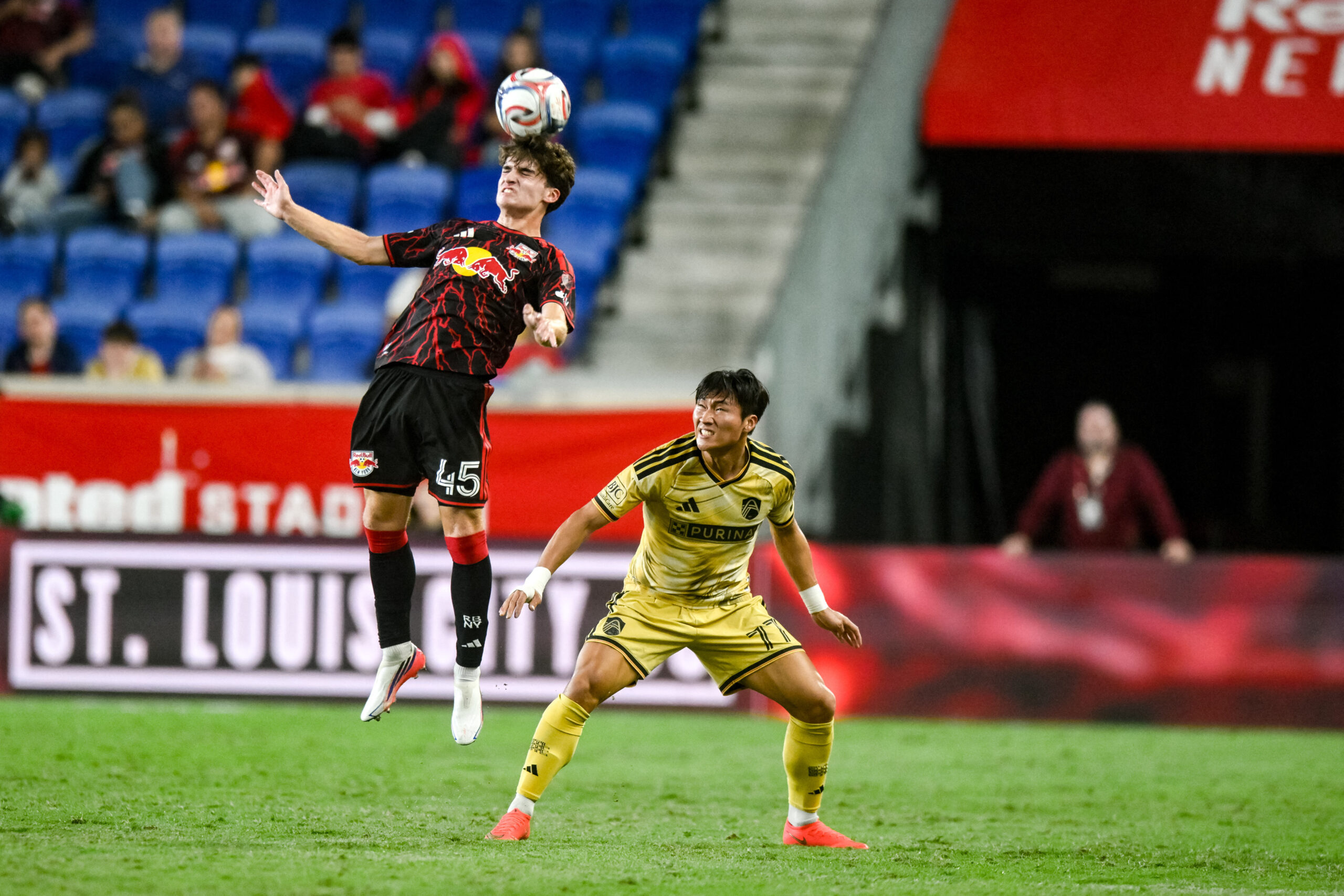 Red Bull New York defender Connor Faello heads the ball against St. Louis CITY SC forward Jeong Sang-Bin during the second half at Sports Illustrated Stadium.