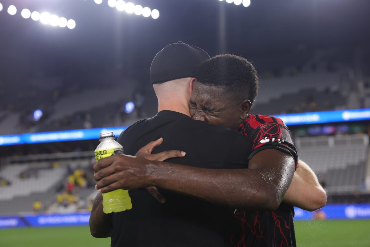 Red Bull New York head coach Michael Bradley embraces defender Julián Bazán after the club's victory against the Columbus Crew.