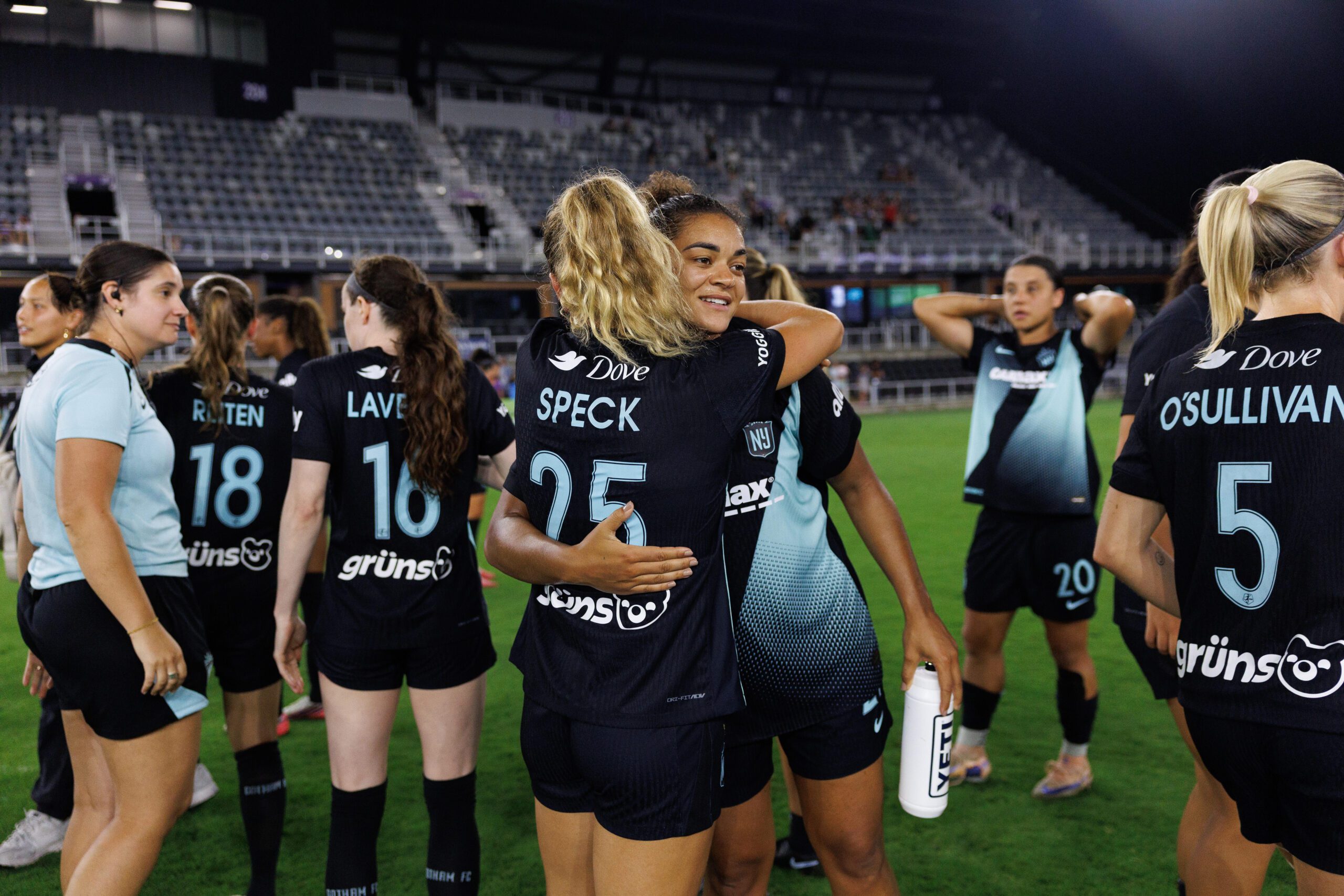 Gotham FC midfielder Meredith Speck and defender Jess Carter (back) embrace after a victory against Racing Louisville FC.