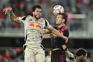 D.C. United defender Lucas Bartlett heads the ball away from Red Bull New York forward Cade Cowell in the first half at Audi Field.